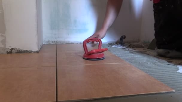 Hombre trabajador colocar baldosas de piso. Renovación del hogar. Diapositiva derecha — Vídeos de Stock