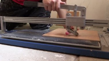 Kiremitçi ellerini kullanarak kesici alet kat döşeme. Sol tarafta slayt