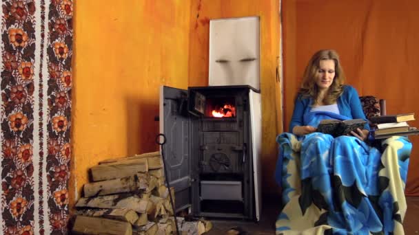 Vrouw Lees boek zitten op leunstoel op koude winterdag. Zoom in — Stockvideo