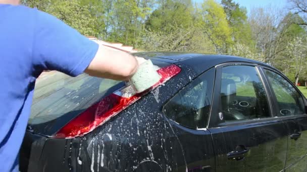 Hombre limpio lavado negro coche favorito con espuma y esponja — Vídeos de Stock