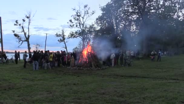 Gente rodeada gran chimenea nea lago en la luz de la noche — Vídeos de Stock