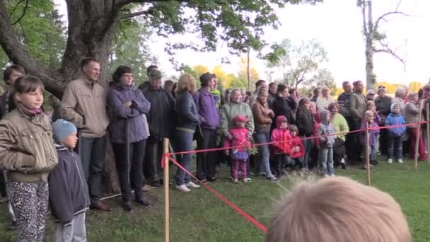 People flock perimeter, children play game blindfold and stick — Stock Video