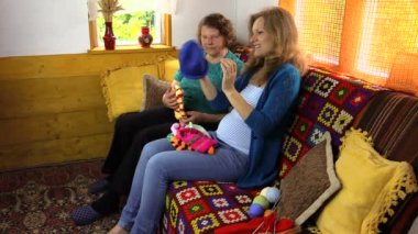 Kadınlar renkli örgü şapka kırsal kanepedeki bak.