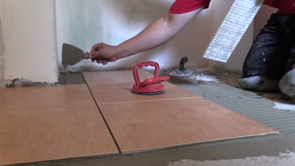 Bauarbeiter verlegen Bodenfliesen. Wohnungsrenovierung — Stockvideo