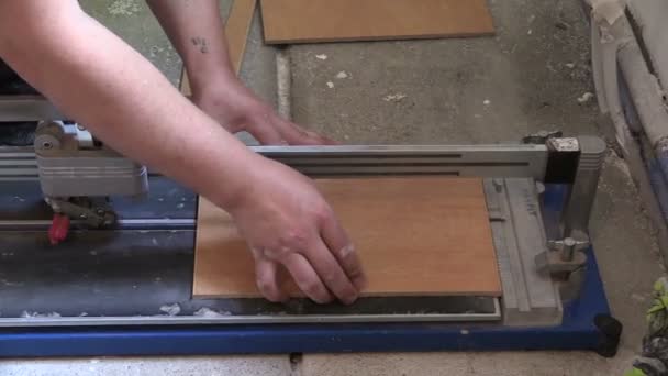 작업자 tiler 남자 사용 타일 바닥에 도구를 잘라. 왼쪽 슬라이딩 — 비디오