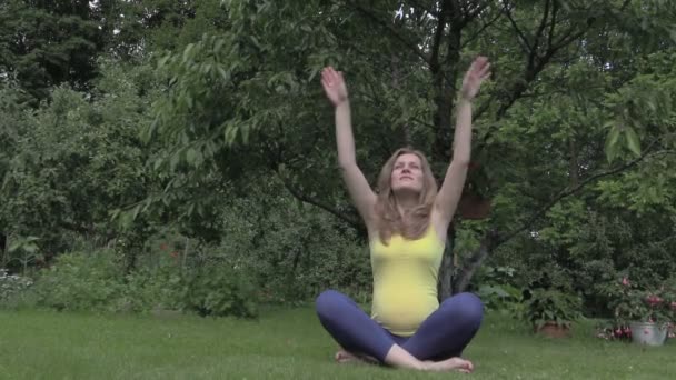Femme enceinte à la méditation de yoga dans le parc. 6 mois enceinte 