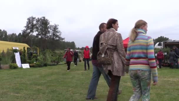 People walk between plants in botanical festival fair — Stock Video