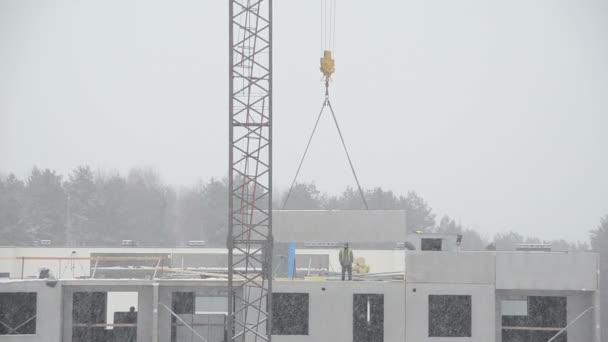 Pieza de la casa de elevación de la grúa y los constructores trabajadores en el techo plano — Vídeo de stock