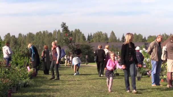 Lidé kupují rostliny a potraviny prodávané v botanické festivalu — Stock video