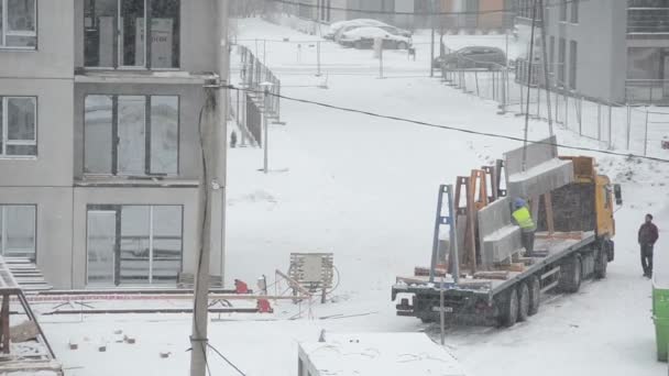 Daru lift blokk ház részét és a téli hóviharban építők — Stock videók