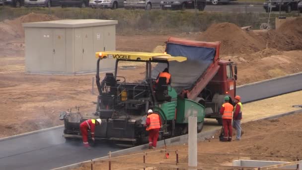 Arbetstagare sprida het asfalt på vägen i bostadshus distrikt — Stockvideo