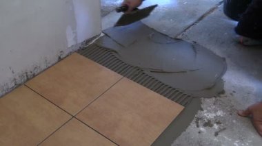 Adam el yapışkan malzeme yaymak. Döşeme karoları. Portre