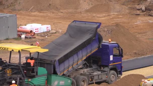 Werknemers met zware machines bestrating asfalt in bouwplaats — Stockvideo