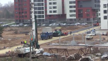 Ağır makineleri düz evler arasındaki asfalt parke ile çalışanları