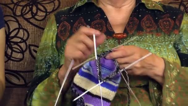 Hands of old grandma knit and young nurse granddaughter on sofa — Stock Video