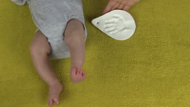 Mother put foot and palm imprints marks near newborn baby — Stock Video