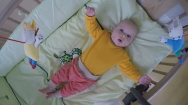 Yatağında atlıkarınca oyuncak bebek bakmak. Yuvarlak top atış spin. 4k