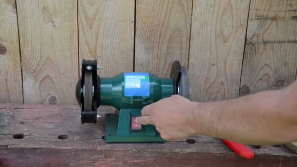 Hand turn on grinder electricity machine and sharpen knives — Stock Video