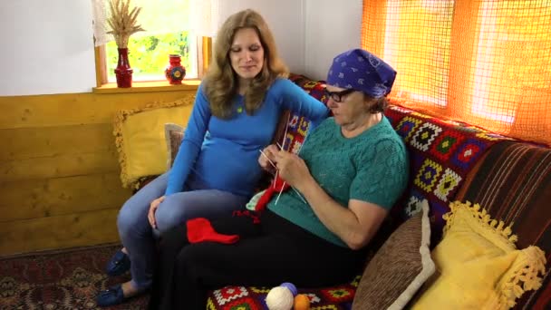 Grand-mère enseigner à sa petite-fille enceinte comment tricoter — Video
