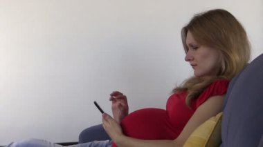 Şirin hamile kadın fotoğrafları ve Internet smartphone ile göz atın