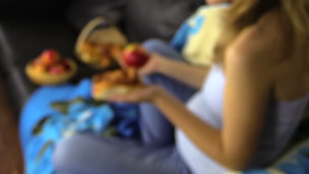 Έγκυος κοπέλα κάνει απόφαση τι να φάει. Apple φρούτα ή λίπος κουλούρι — Αρχείο Βίντεο