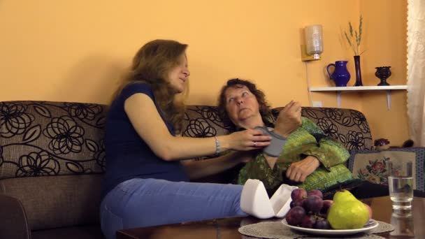 Granny measuring blood pressure on carpus, woman bring water — Stock Video