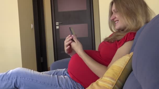 Speelse zwangere vrouw zelfportret foto nemen op mobiele telefoon — Stockvideo