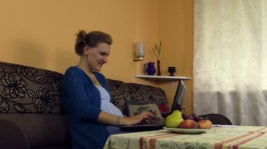 Mutlu hamile kadın iş laptop ile ve kalemle yazmak