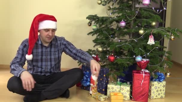 Zabawny człowiek rozwijać czekolada Christmas Santa i lizać usta — Wideo stockowe