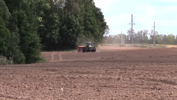 Tractor spread fertilizer on cultivated field in autumn — Stock Video