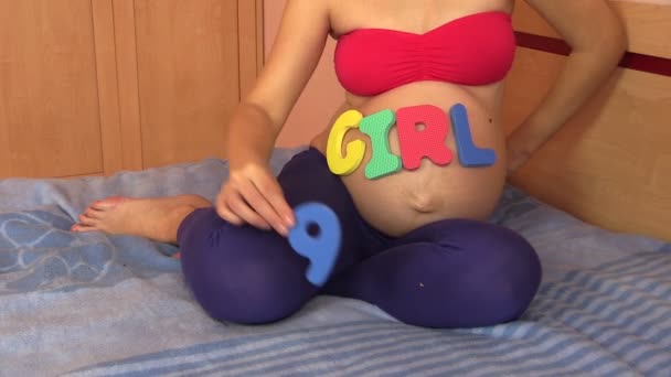 Woman with girl word on belly in 9 ninth pregnancy month — ストック動画