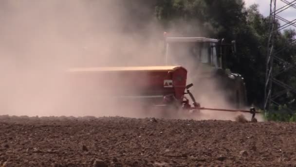 Dust rising from tractor fertilizer prepare soil in field — Stock Video