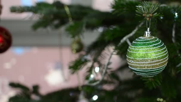 Frau hängt dekorative Spielzeugkugel an Ast des Weihnachtsbaums — Stockvideo