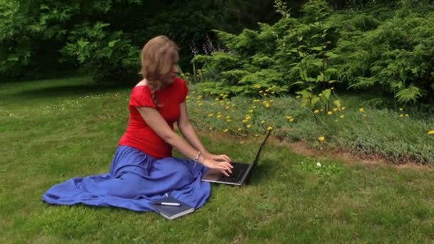 Беременная женщина смотреть ноутбук компьютер и писать на бумаге ноутбука — стоковое видео