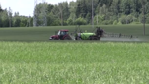 Tractor fertilizar el campo de cultivo en herbicidas, pesticidas. Panorama — Vídeo de stock