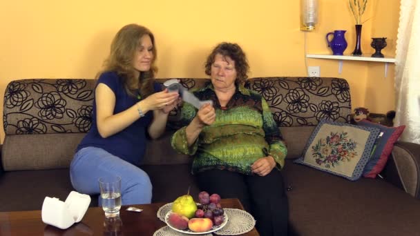 Schwangere misst bei Seniorin Blutdruck und gibt Pille — Stockvideo