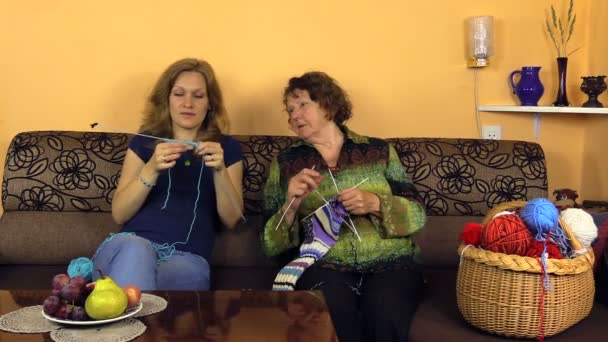 Happy old grandma knit with nurse girl on sofa in nursing home — Stock Video