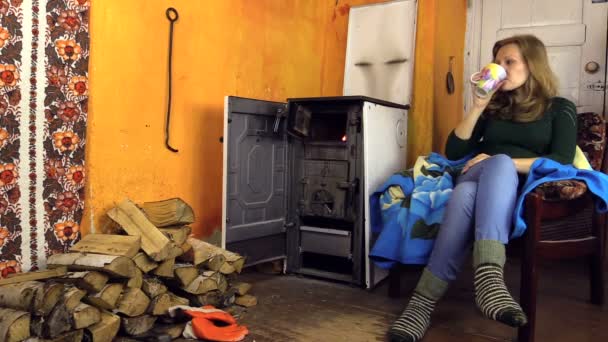 Vrouw met wollen sokken sluit oude kachel deur en verlaten van de kamer — Stockvideo
