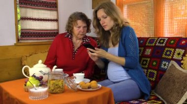 kız ve büyükanne tabloda çay ile izle Foto telefonla oturmak