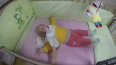 Anne el aç bebek kız şişe süt ile beslemek. 4k