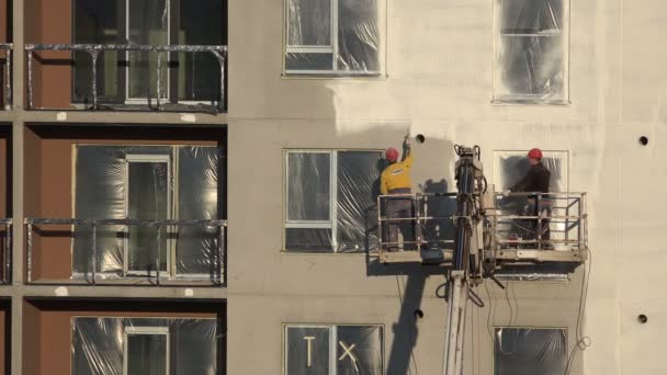 Építő férfiak festék a ház falán a permetező eszközt. 4k — Stock videók