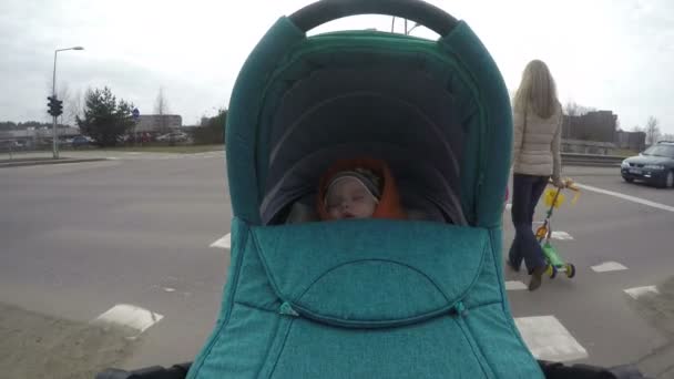 Lopen met baby wandelwagen door voetgangers straat oversteken. 4k — Stockvideo