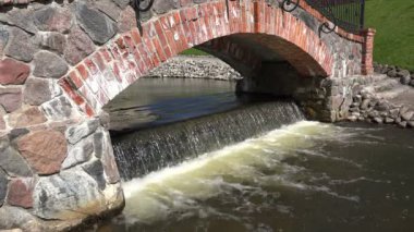 Retro kırmızı tuğla ve taş kemer ve şelale akan su. 4k
