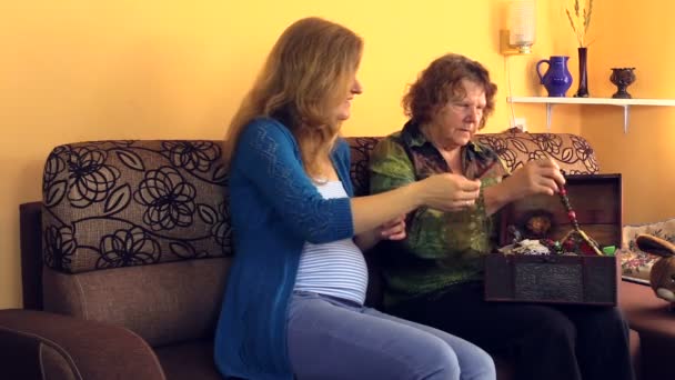 Старая бабушка дарит ожерелье для девушки из ювелирного сундука — стоковое видео