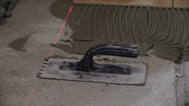 Worker man lay ceramic floor tiles in kitchen. Zoom out — Stock Video