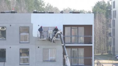 İnşaatçılar erkekler yeni yapı modern ev duvarları beyaz boya. 4k