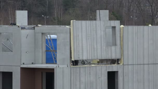 Рабочие с краном прикрепляют бетонные блоки стены дома. 4K — стоковое видео