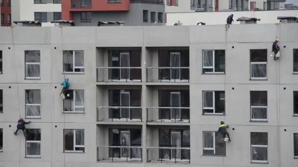 Constructores de gran escala que trabajan en la pared de la casa en el sitio de construcción — Vídeo de stock