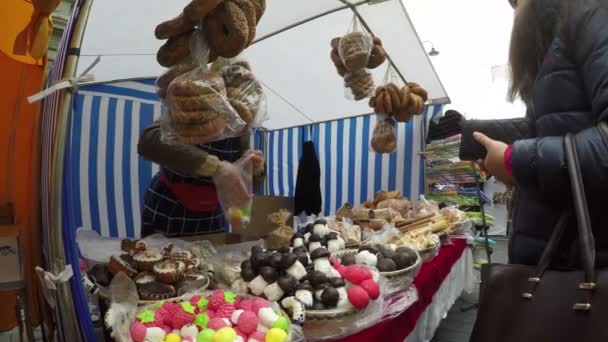 Young woman pay vendor for colorful sweets at candy store market — Stock Video