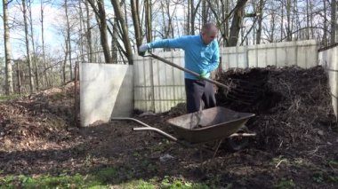 Bahçe işçi dirgen ile kompost humus barrow için kazmak. 4k